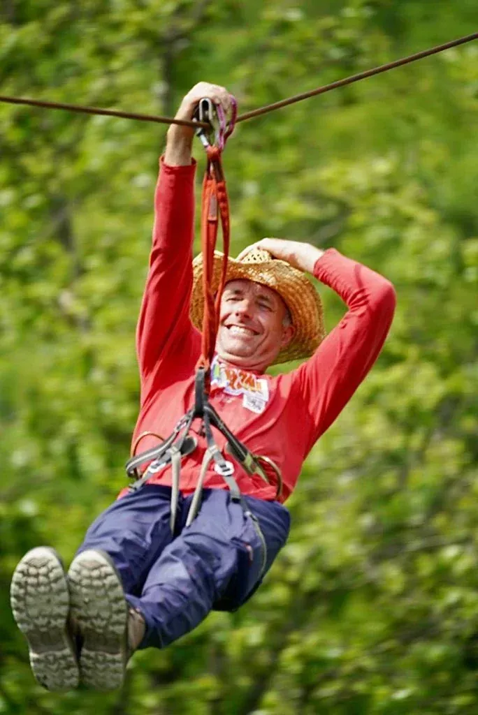 Gost na velikoj zipline s pogledom na šumu u Glavani Parku, Istria